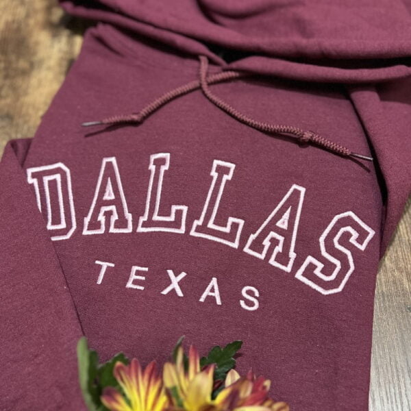 Dallas custom embroidered hoodie. Light pink thread on maroon hoodie.