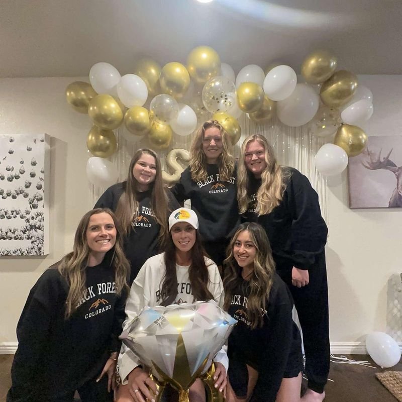 Customer photo: group of friends in matching Black Forest Colorado embroidered sweatshirts at a celebration