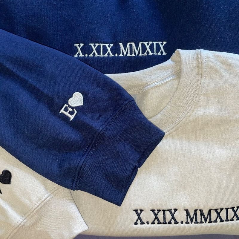 Customer photo: navy and white crewnecks with Roman numeral date and heart initial on the sleeve