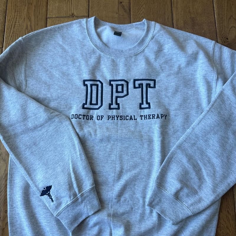 Customer photo: heather gray crewneck embroidered DPT Doctor of Physical Therapy with a caduceus on the sleeve